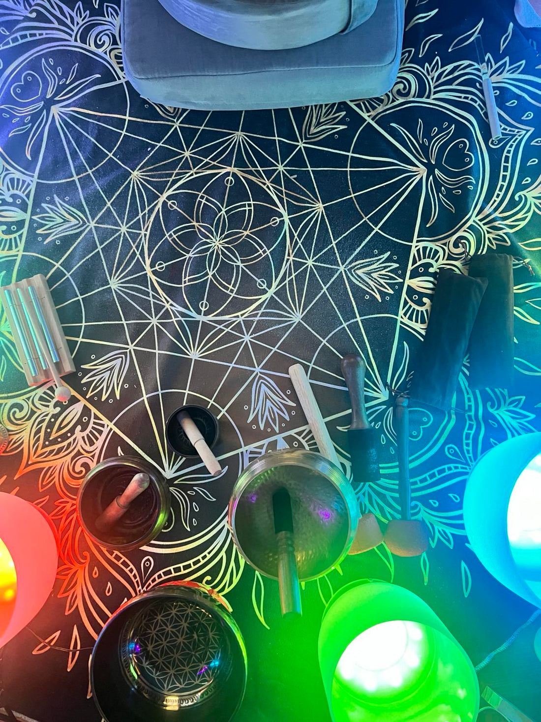 Image of a serene sound bath session with lighted singing bowls and a floor tapestry