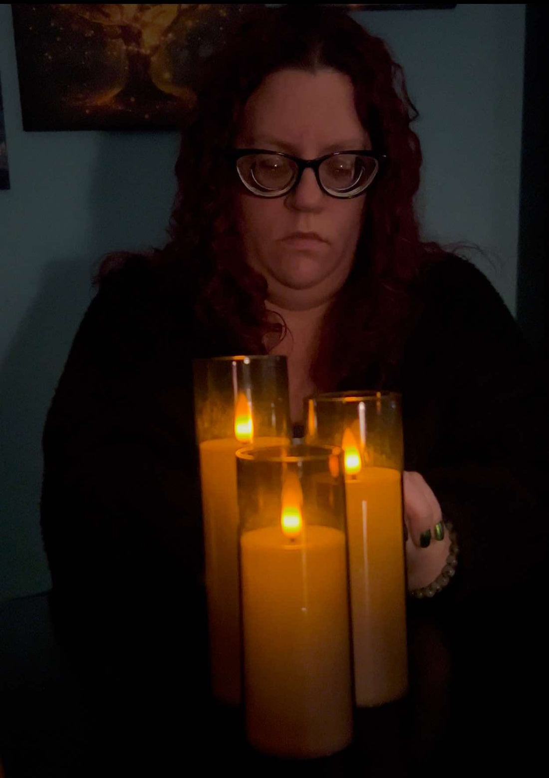 A Beautiful Woman in Deep Meditation with a pair of 3 glowing candles in front of her.