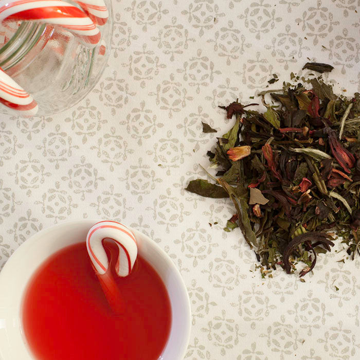 Candy Cane White Tea loose leaves Brewed cup of Candy Cane White Tea Holiday-themed tea setup Close-up of tea ingredients Packaging of Candy Cane White Tea